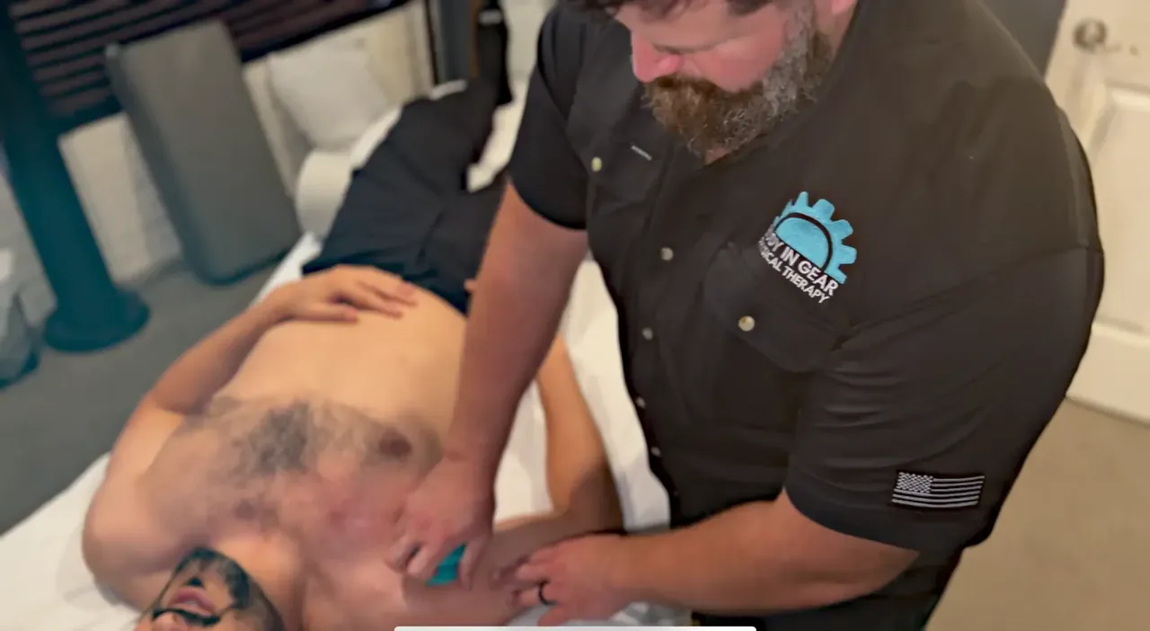 Medical massage therapist assessing shoulder range of motion before treatment at Body In Gear in Palatine, IL